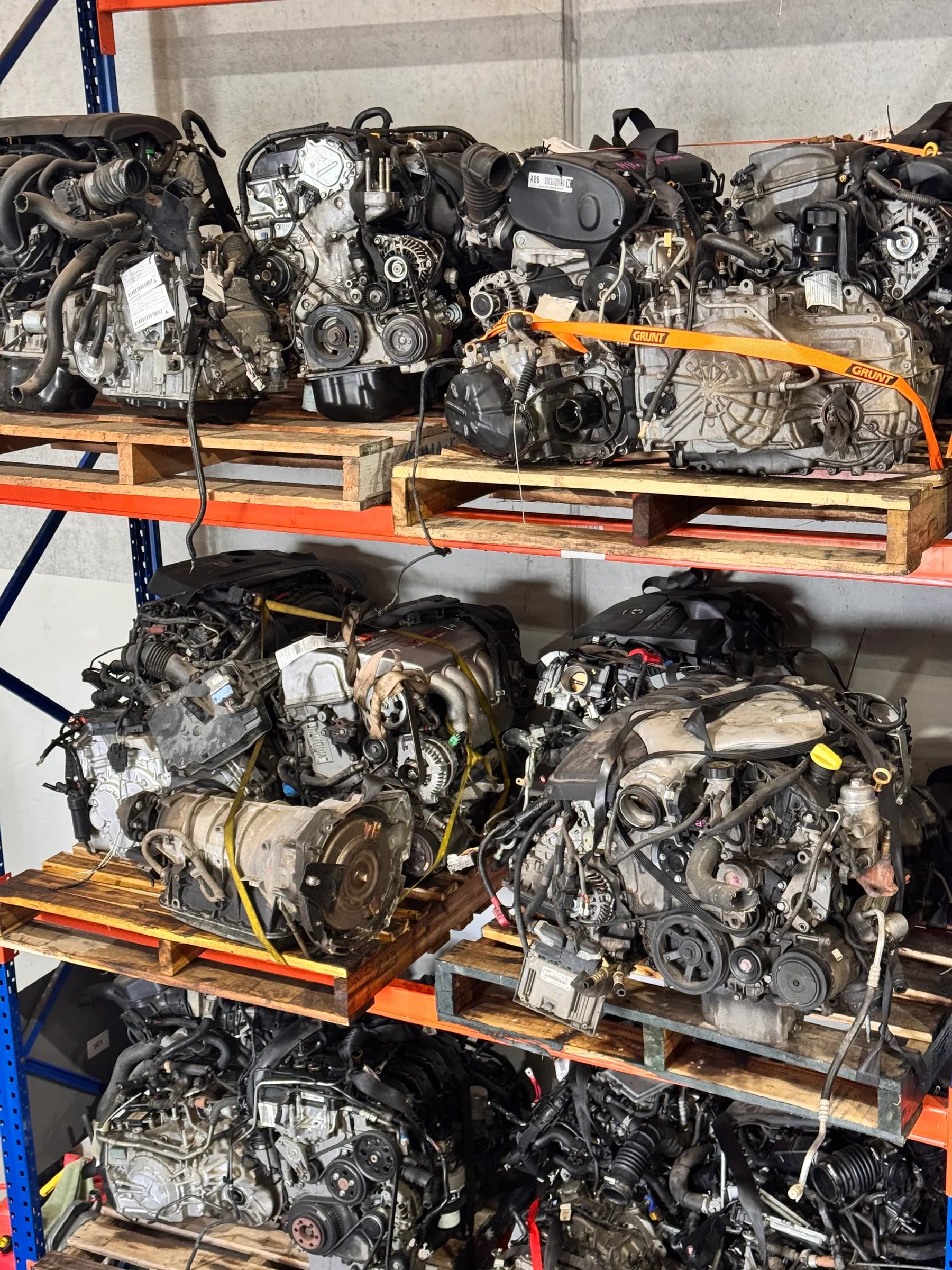 Used engines stacked on pallets and labelled for matching.