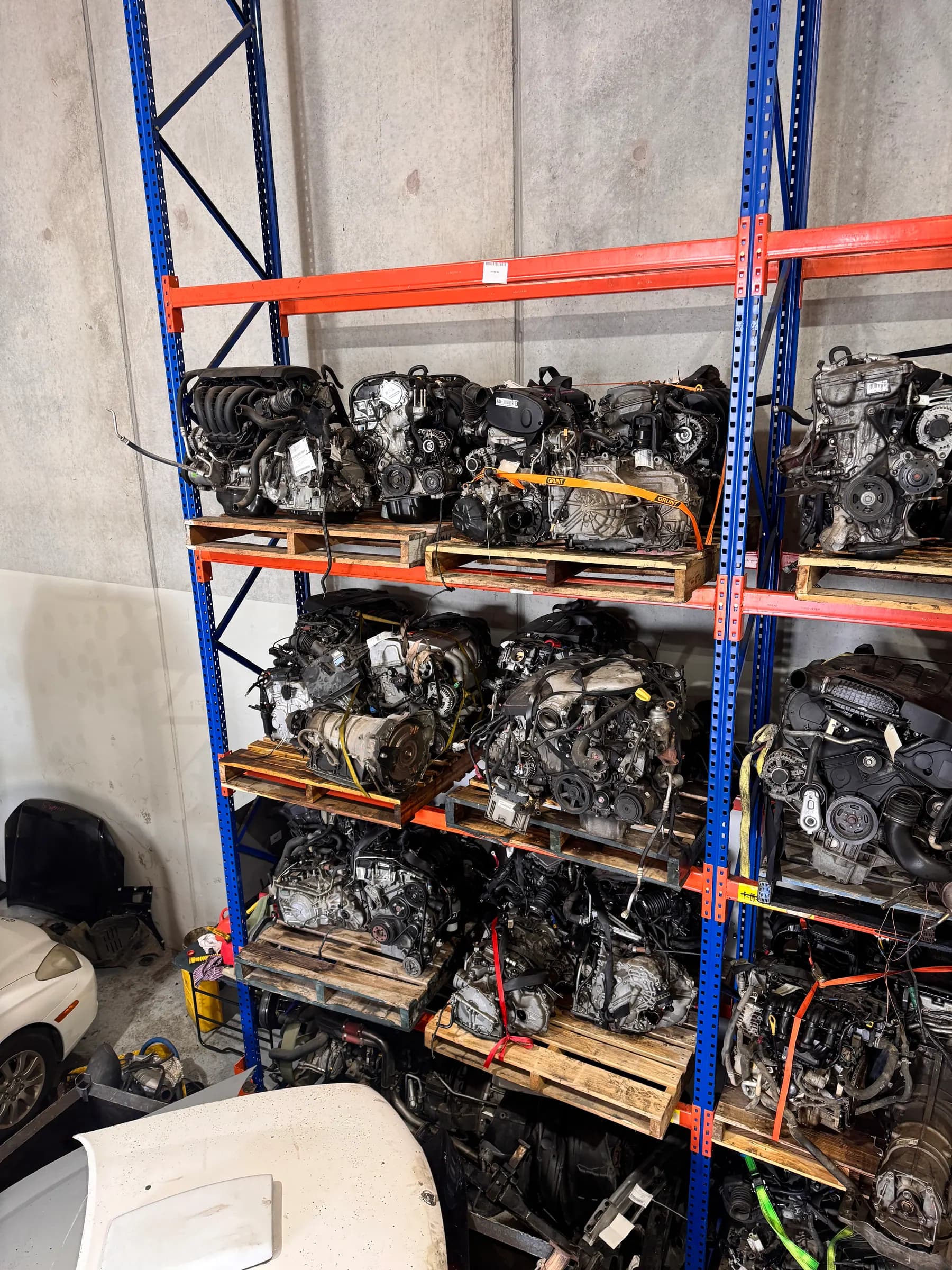 Rows of dismantled engines stored on warehouse shelving.