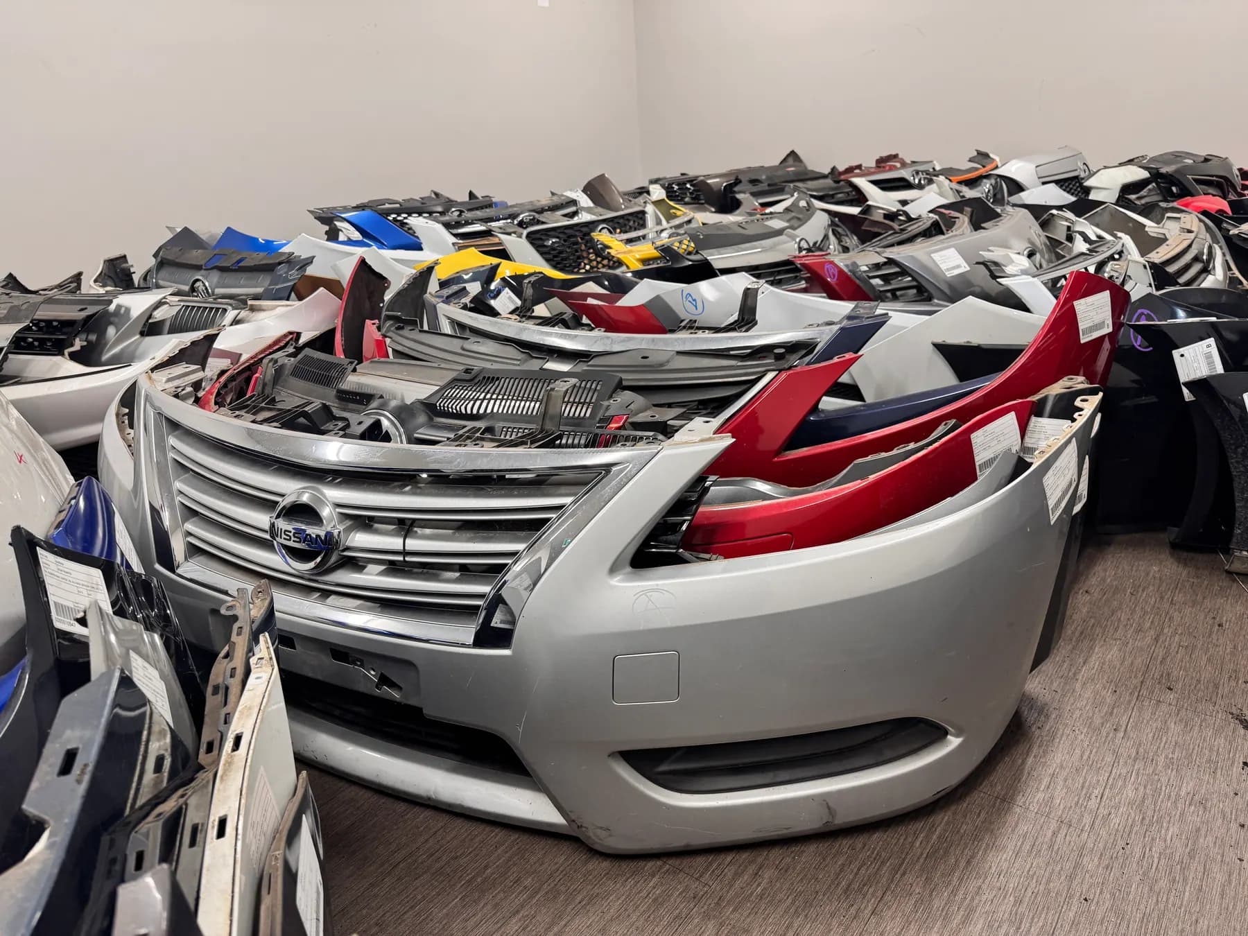 Front bumper bars and grilles stacked in the PartsBase warehouse.